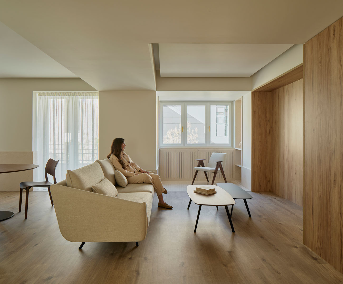 Zona de estar del apartamento Calasanz con sofá y paramentos de madera