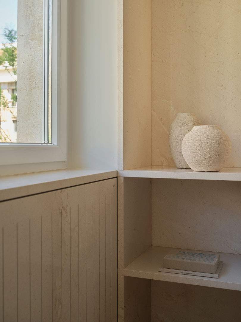 Ventana y estantería de madera con jarrones en el apartamento Calasanz
