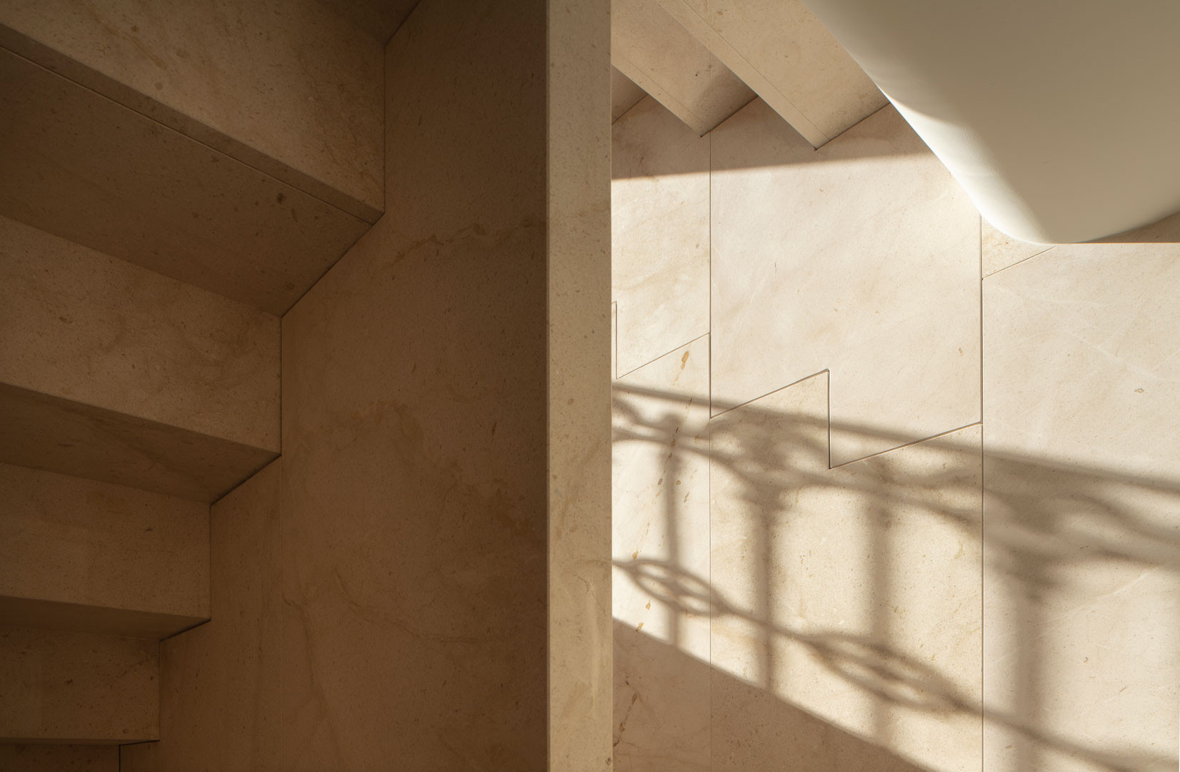 Escalera de la Casa de los Gigantes con la sombra de la rejería sobre el muro