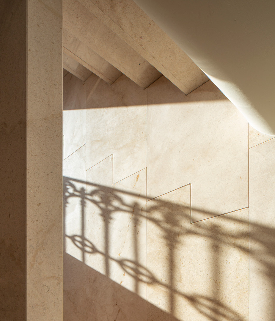 Escalera de piedra de la Casa de los Gigantes con la sombra de la barandilla sobre el paramento