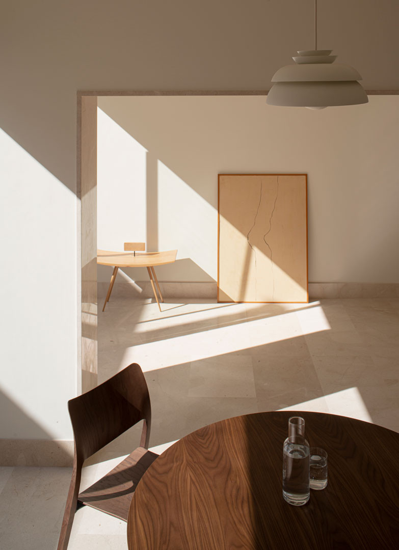 Mesa de comedor con luz y sombras proyectadas en la Casa del Limonero