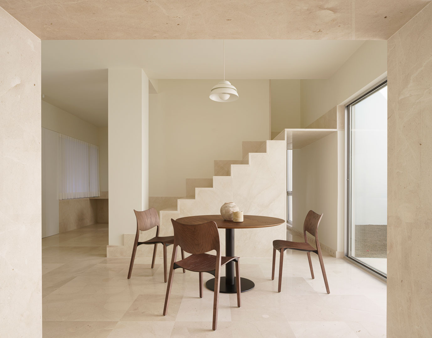 Comedor de la Casa del Limonero con la escalera de piedra tras la mesa