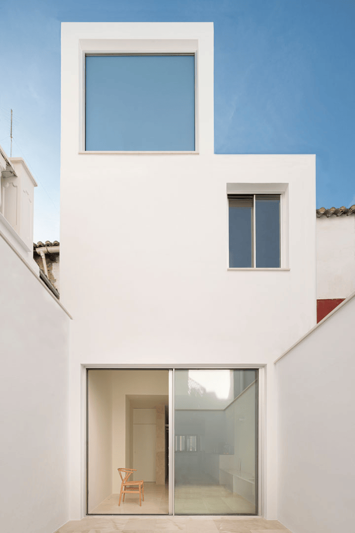 Fachada trasera blanca de Casa Mirasol sobre el patio