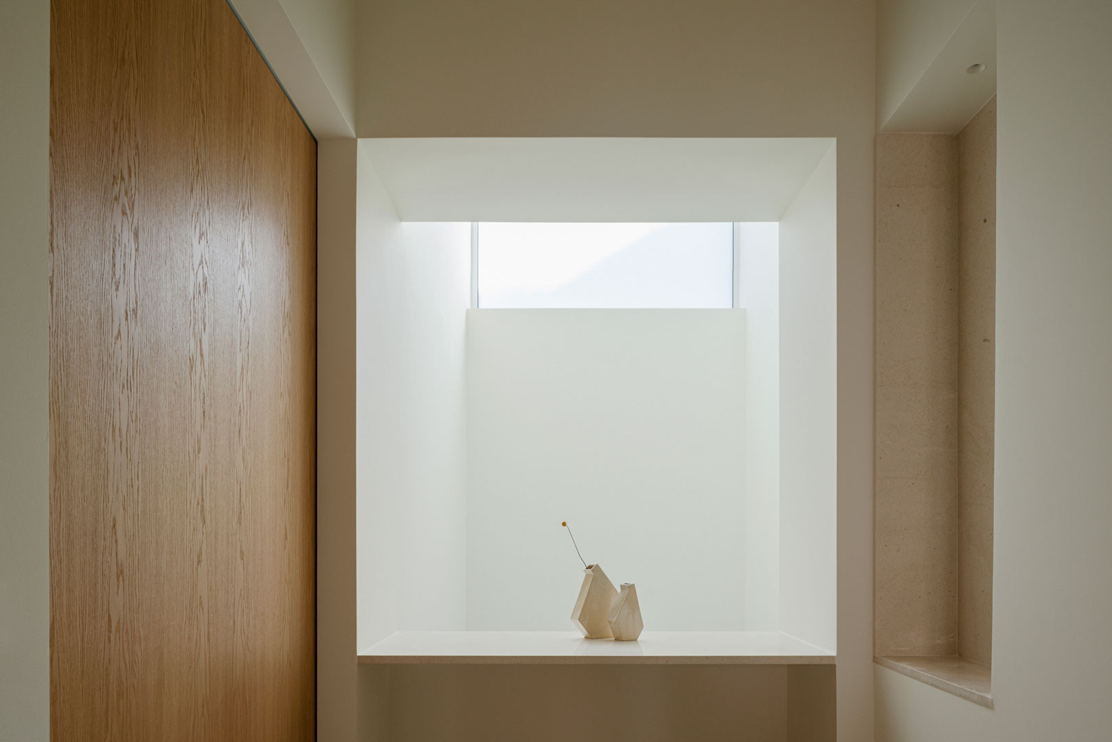 Hueco con ventana y banco de piedra junto a un paramento de roble en Casa Mirasol