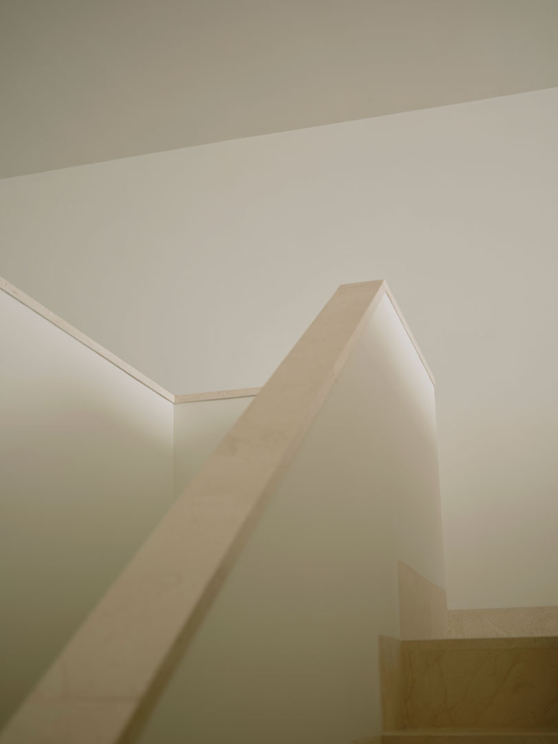 Escalera de piedra de Casa Nido con su barandilla maciza bañada por la luz