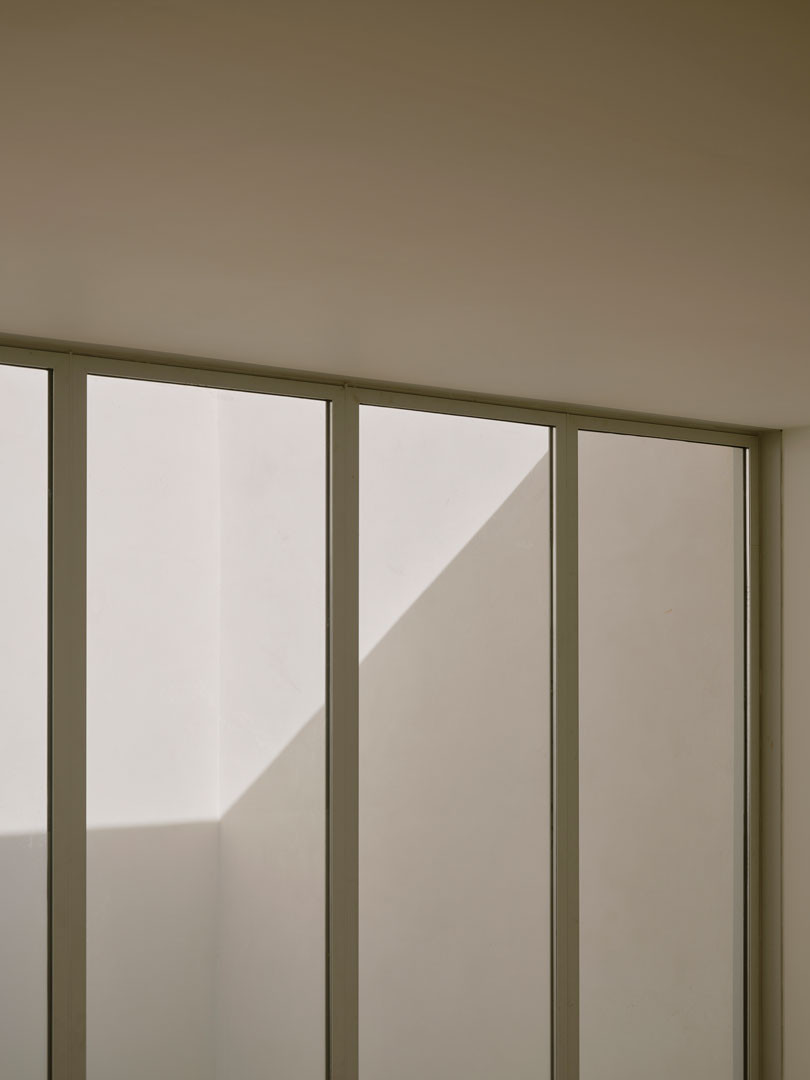 Ventanal de Casa Nido con la luz y la sombra proyectadas sobre el muro