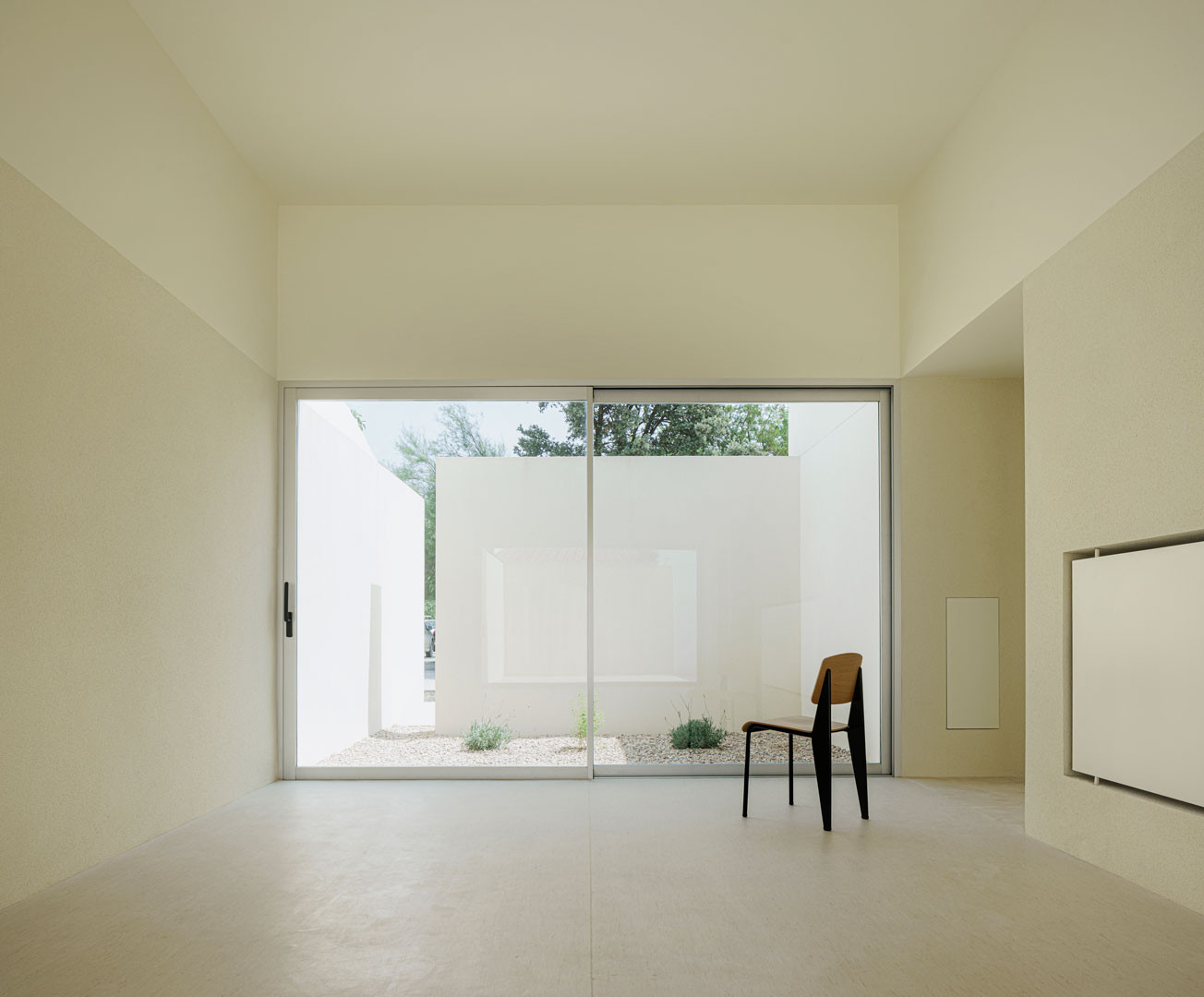 Sala de la Escuela en Aguas Nuevas con una silla frente al ventanal del patio