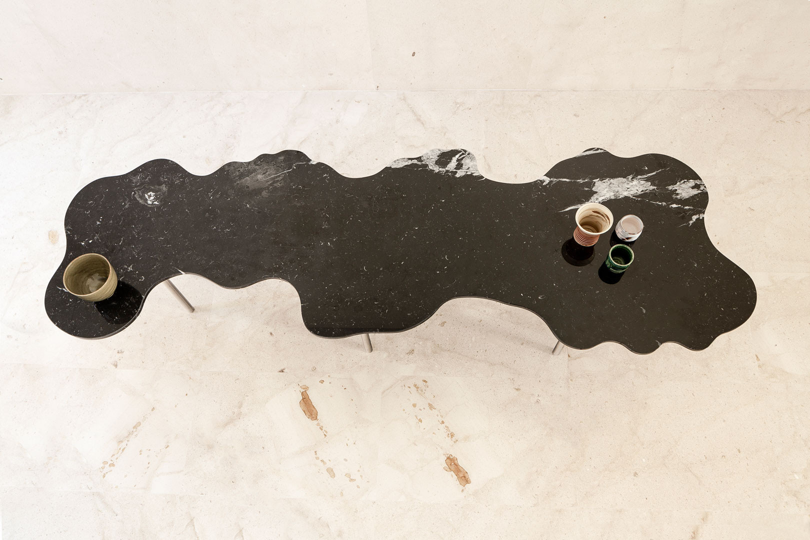 Top view of the Lago table, with its dark organic-edged top and a pair of bowls