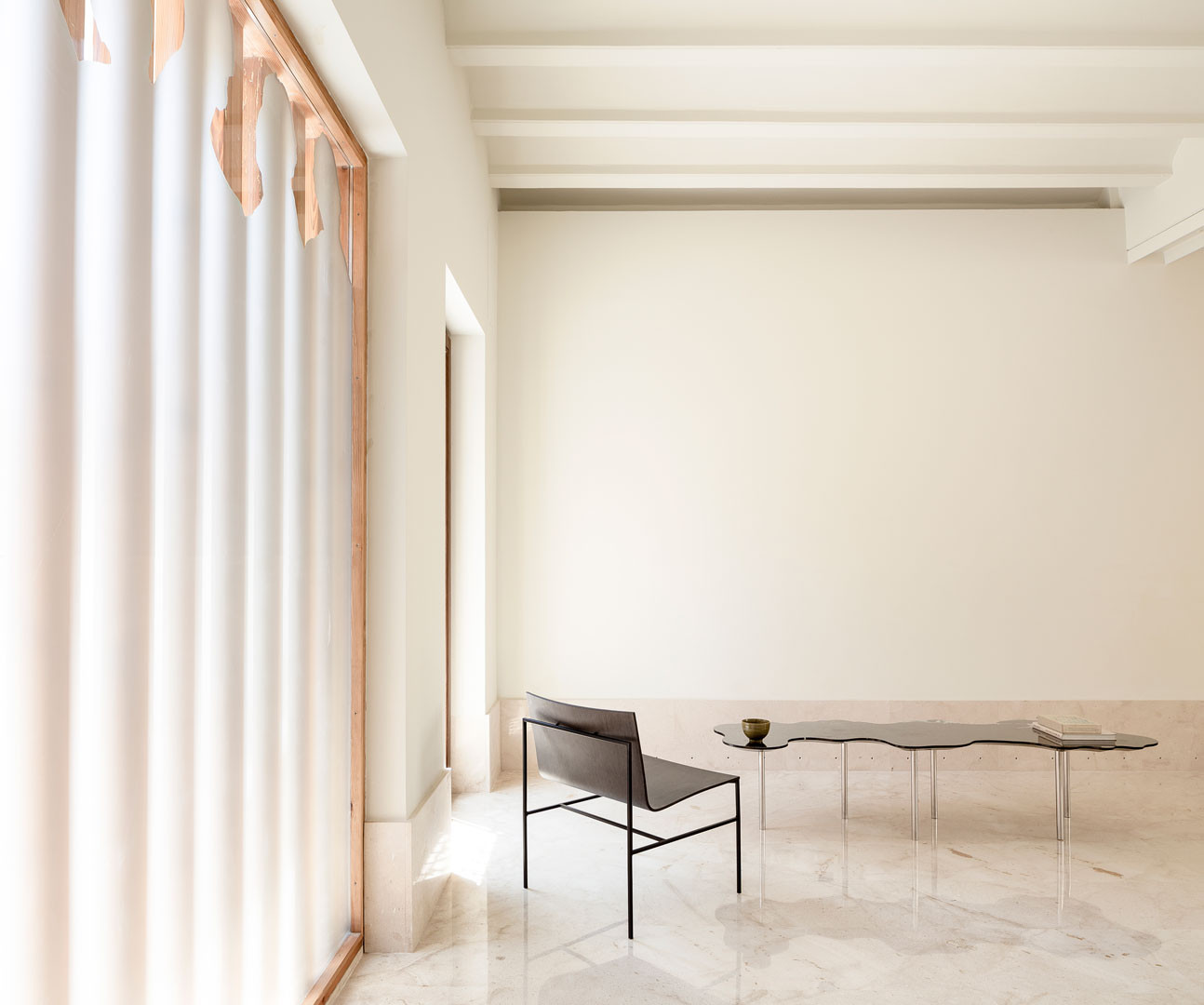 Lago table in a bright room beside a chair