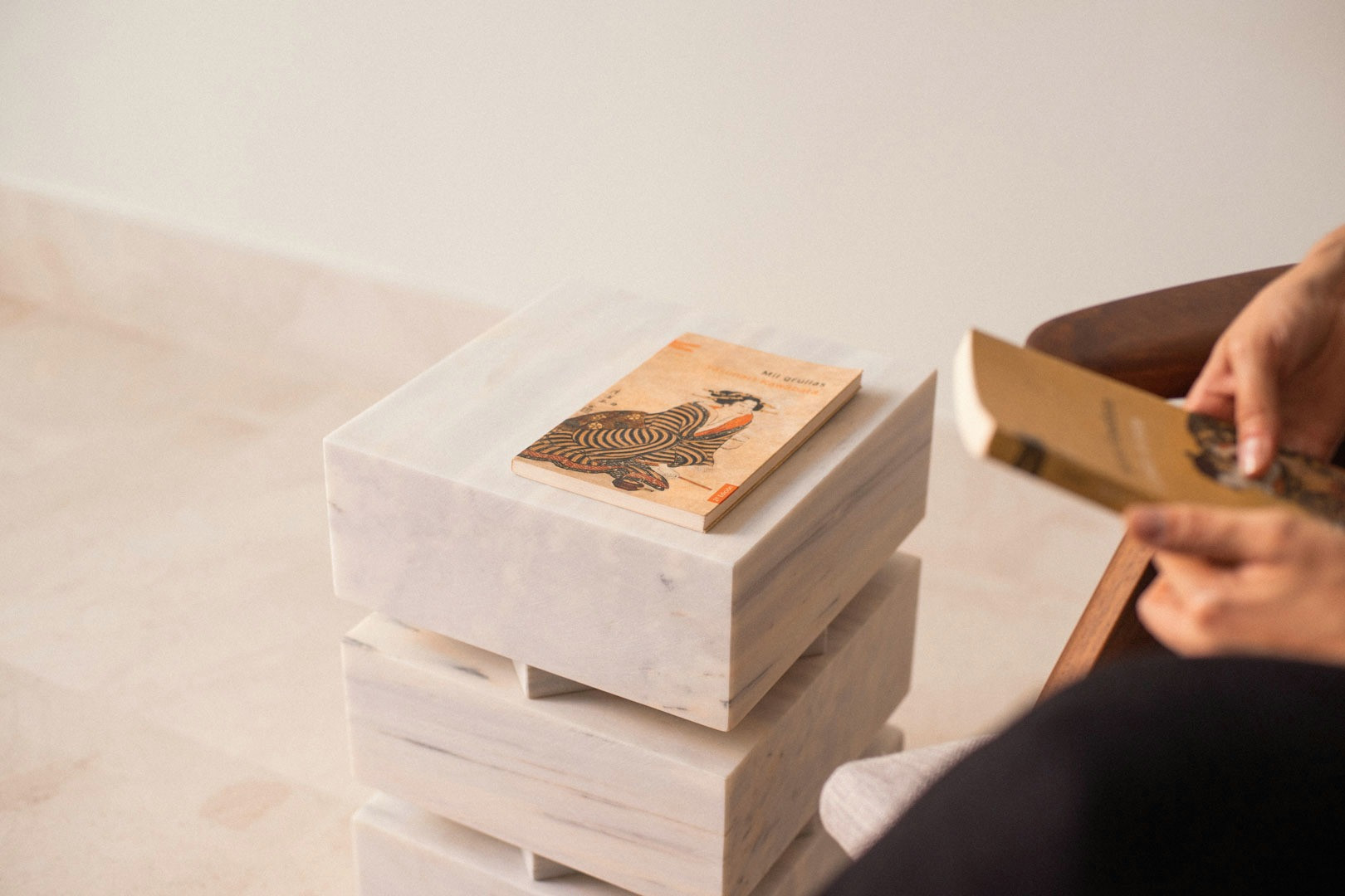 A hand placing a book on the stacked modules of Pilas