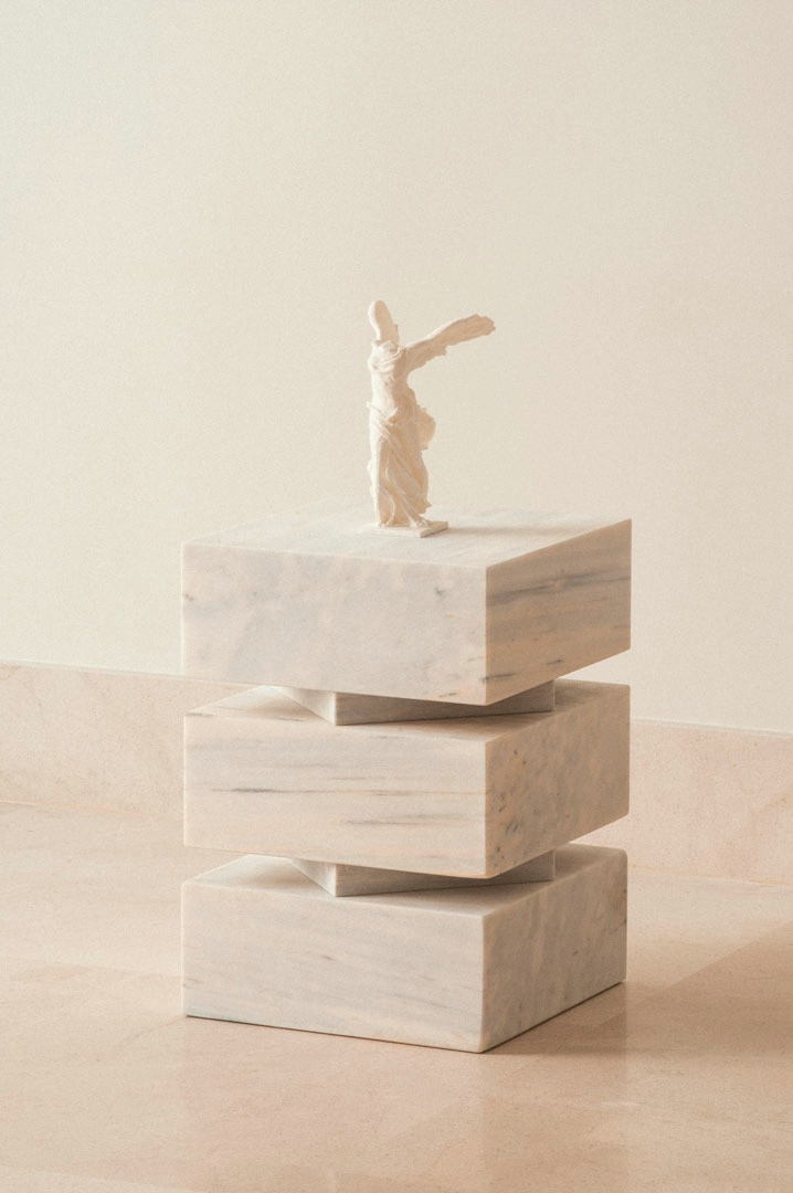 Pilas, módulos claros apilados con una pequeña figura encima, como escultura