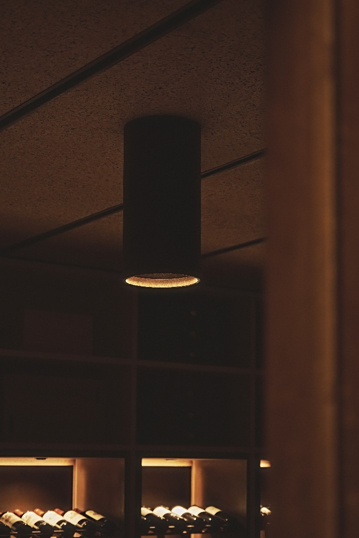Lamp above the bottle shelving in Tinta